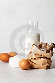 Bakery products -flour, eggs, milk, sugar on white background. Selective focus