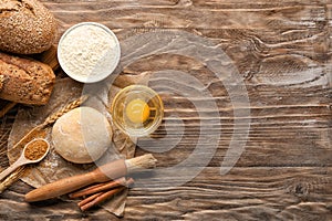 Bakery products with ingredients on wooden background