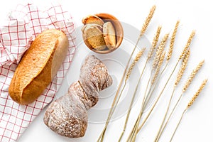 Bakery set with fresh wheaten bread on table white background top view