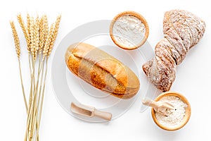 Bakery set with fresh wheaten bread on table white background top view