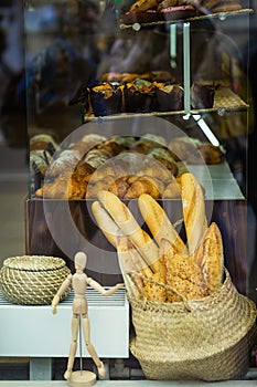 Bakery Showcase. Freshly baked bread and rolls, traditional french pastries. Wicker basket with fresh crispy baguettes
