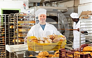 Bakery worker carrying box with loaves