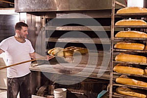 Bakery worker taking out freshly baked breads