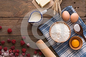 Baking background with copy space. Cooking ingredients for yeast dough and pastry, eggs, flour and milk on white rustic wood. Mock