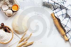 Baking background with dough and ingredients for the preparation of pasta or pancakes, eggs, flour, water and salt on white rustic
