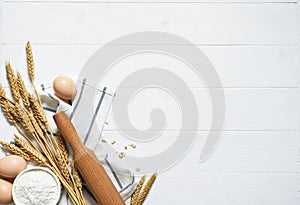 Baking background with flour, wheat ears and rolling pinon concrete background. Top view with copy space