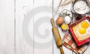 Baking background. Ingredients for the dough - Egg, flour and a rolling pin.