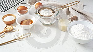 Baking background, pastry or cake ingredients, sifting flour, brown sugar, eggs and milk with utensil
