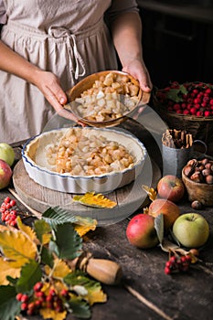 Baking background with raw traditional classic apple pie, bake  ingredients and utensils. Homemade  cake surrounded by fresh