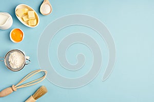 Baking background with  whisk, egg, flour , sugar, butter on blue table top view. Flat lay