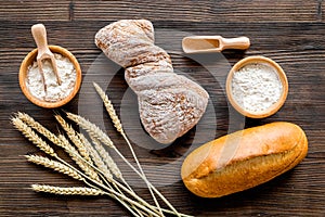Baking bread with wheat flour and ears on table rystic background top view