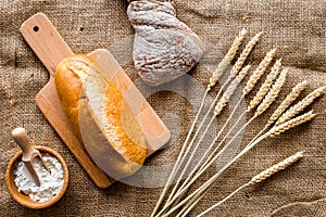 Baking bread with wheat flour and ears on table rystic background top view