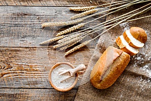 Baking bread with wheat flour and ears on table rystic background top view mockup