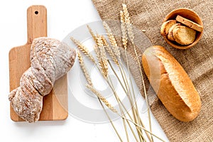 Baking bread with wheat flour and ears on table white background top view