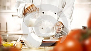 Baking a cake and bread. Chefâ€™s female hands preparing food in the kitchen. Woman in white chef uniform.