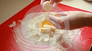 Baking cake. Hands adding egg to flour and butter