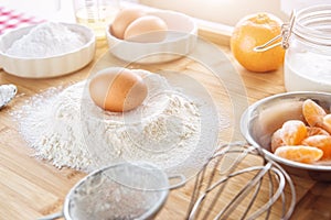 Baking cake in kitchen - dough recipe ingredients with fruit on wood table