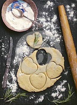 Baking cheese cookies recipe photo of empty food background with cookies heart shape cut out of dough, rolling pin, flour,