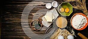 Baking concept - baking ingredients butter, flour, sugar, eggs on rustic wood background