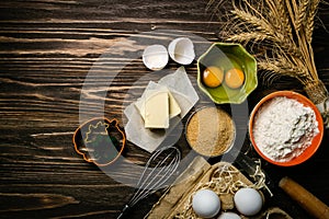 Baking concept - baking ingredients butter, flour, sugar, eggs on rustic wood background