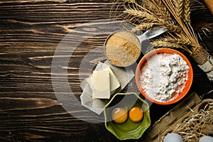 Baking concept - baking ingredients butter, flour, sugar, eggs on rustic wood background