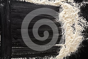 Baking concept on black background, sprinkled flour with copy space