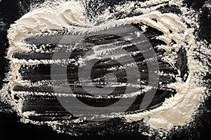 Baking concept on black background, sprinkled flour with copy space