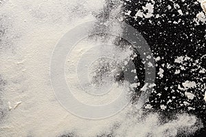 Baking concept on black background, sprinkled flour with copy space