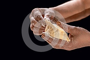 Baking concept, hands kneading dough on black background. Old woman hands rolling doughs for pies. Hands pie dough