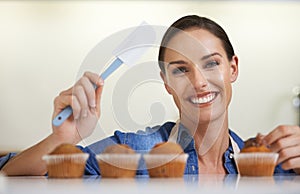 Baking, cupcakes and portrait of woman with spatula in kitchen with sweet chocolate frosting for dessert. Cooking, smile