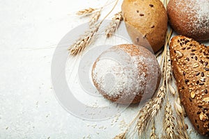 Baking fresh wheat bread with flour and grain on a white table, top view