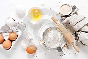 Baking homemade bread on white kitchen worktop with ingredients for cooking, culinary background, copy space