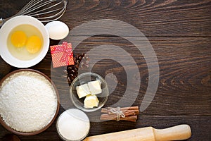 Baking ingredients for christmas cake with cinnamon on rustic wooden background.