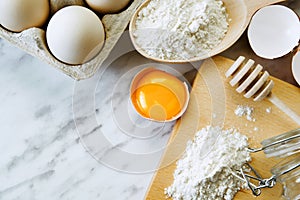 Baking ingredients with eggs and flour on marble table. Flat lay