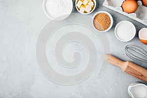 Baking ingredients. Flour, eggs, sugar, butter, roller pin and whisk on the kitchen table