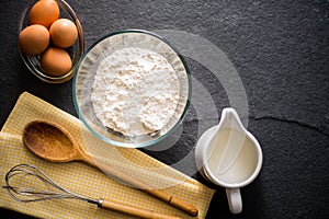 Baking ingredients - flour, milk, eggs with a whisk