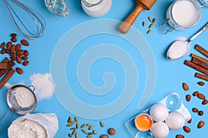 Baking ingredients for homemade pastry on blue background. Bake sweet cake dessert concept. Top view. Flat lay