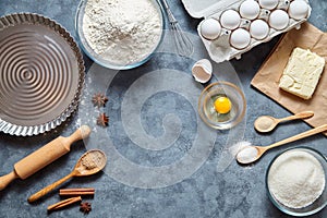 Baking ingredients for homemade pastry on dark background. Bake sweet cake dessert concept. Top view, flat lay