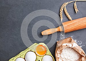 Baking ingredients and items on the black stone background