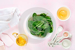 Baking ingredients and kitchen utensils on a pink background, top view