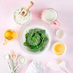 Baking ingredients and kitchen utensils on a pink background, top view