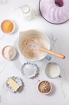Baking ingredients and kitchen utensils on white wooden background