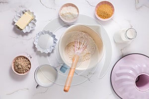 Baking ingredients and kitchen utensils on white wooden background