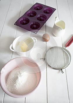 Baking ingredients lie on a white wooden table