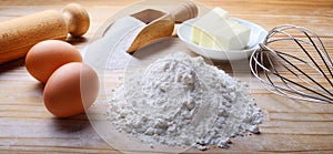 Baking ingredients on pastry board. Eggs, butter, sugar and flour.