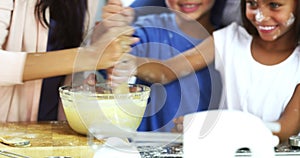 Baking, kids and laugh with mom at home in a kitchen with mixing bowl playing. House, mother and children cooking with