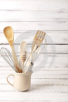 Baking kitchenware and baking products on white wooden background