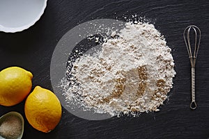 Baking lemon pie foodist kitchen pile of flour on dark worktop