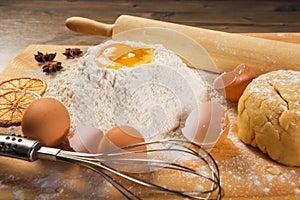 Baking preparation: eggs, flour, rolling pin, spices on a board