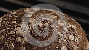 Baking rye bread with cereals and seeds in a grilled oven. Stock footage. Close up of round shaped loaf of tasty and